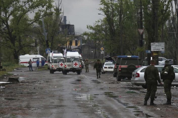Red Cross staff drive by in their vehicles to the besieged Mariupol's Azovstal steel plant to observe the evacuation of Ukrainian servicemen from Azovstal steel plant, in Mariupol, in territory under the government of the Donetsk People's Republic, eastern Ukraine, Wednesday, May 18, 2022. (AP Photo)