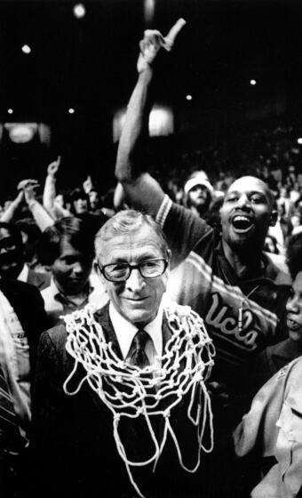 UCLA basketball coach John Wooden wears a basketball net around his neck after his team won the 1975 NCAA championship