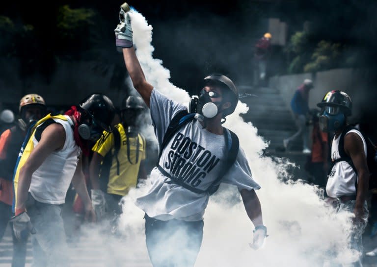 Opposition activists clash with riot police during a protest against the government of President Nicolas Maduro in Caracas on May 20, 2017