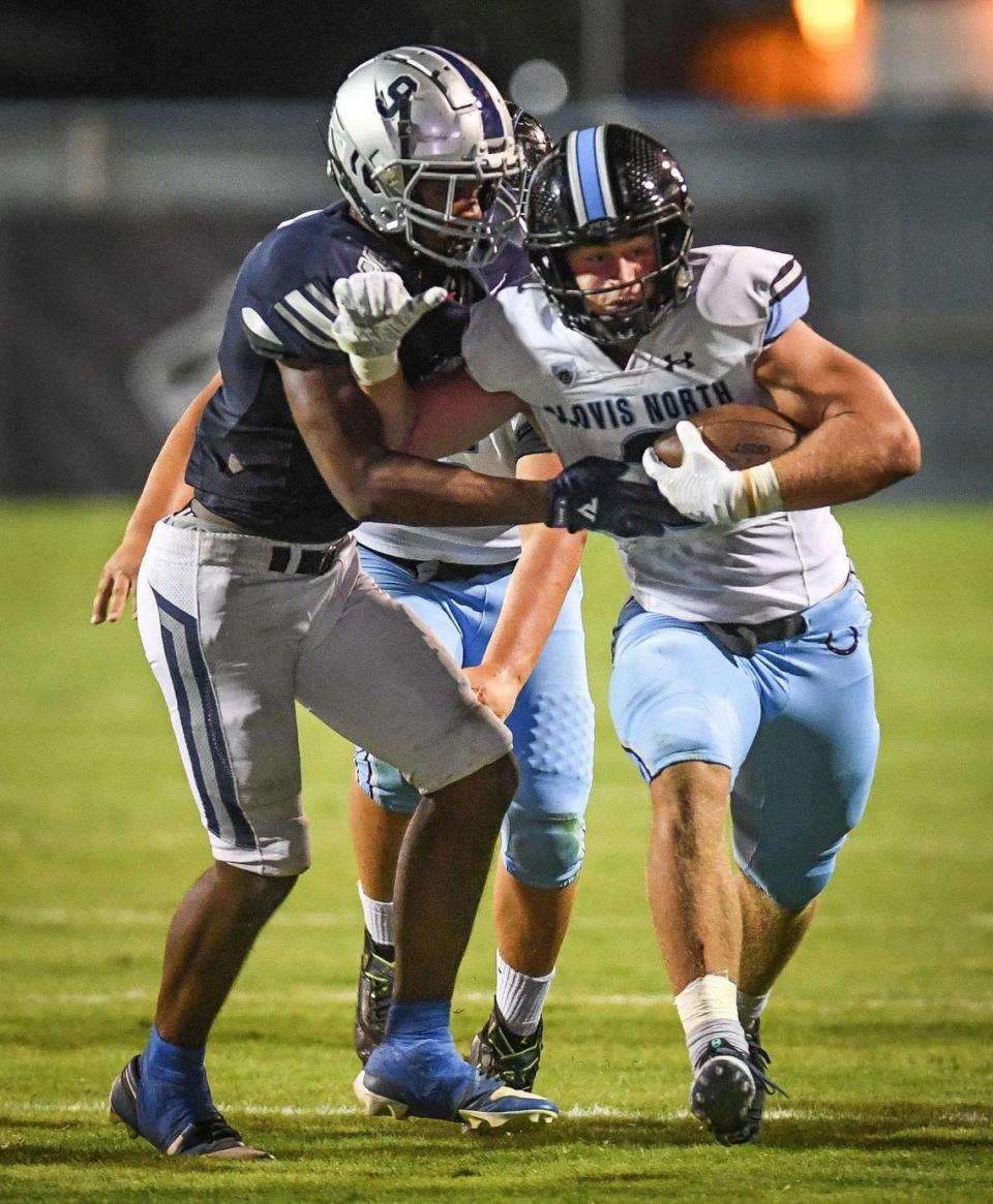 Clovis North’s McKay Madsen, right, tries to get by Clovis East’s Nathaniel Thompson on a run up the middle during their TRAC opener at Lamonica Stadium on Friday, Sept. 29, 2023. CRAIG KOHLRUSS/ckohlruss@fresnobee.com