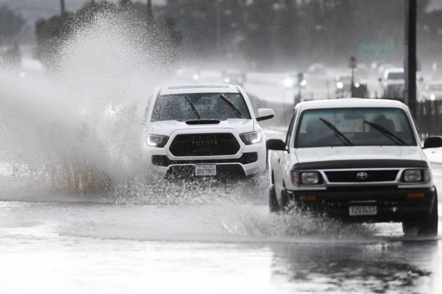 Trucks drive down a flooded street, Tuesday, Feb. 6, 2024, in Lakeside, Calif. The National Weather Service issued a tornado warning for parts of East San Diego county including Lakeside. (AP Photo/Denis Poroy)