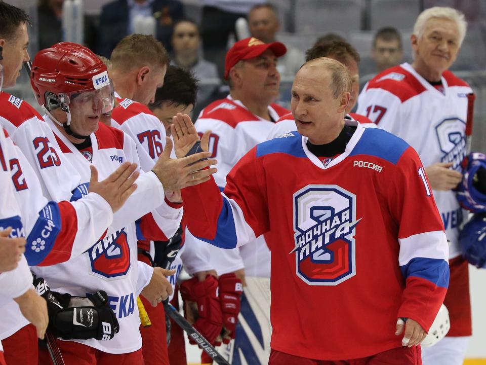 Russian President Vladimir Putin (C) greets billionaire and businessman Vladimir Potanin (L) as billionaire Gennady Timchenko (R) looks on during a group photo at the gala match of the Night Hockey League at Bolshoi Ice Dome in Sochi, Russia, May,10, 2019.