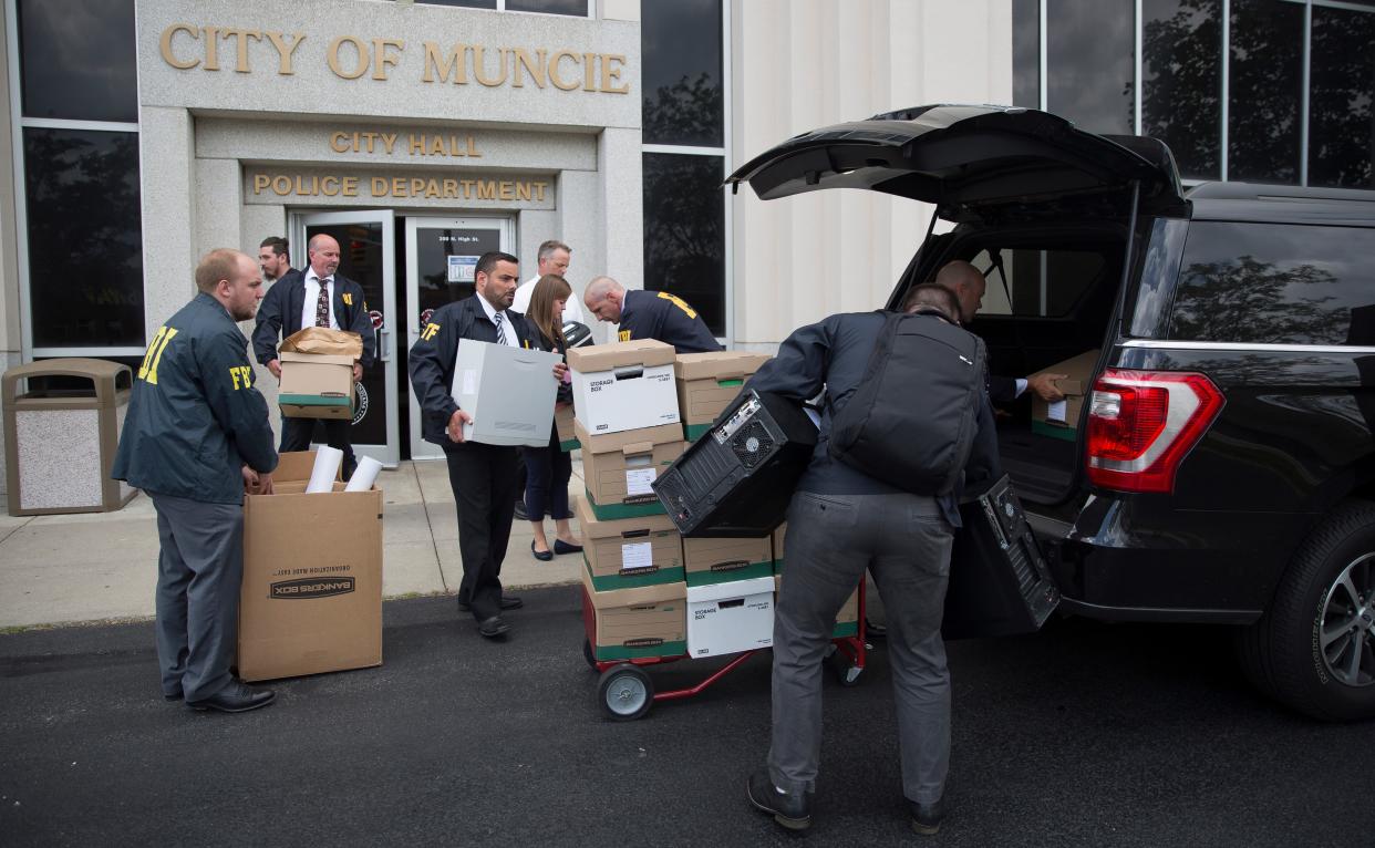 Agents and support staff with the FBI carry out documents and computers from Muncie City Hall in July 2019 after raiding two Muncie Sanitary District offices inside the building.