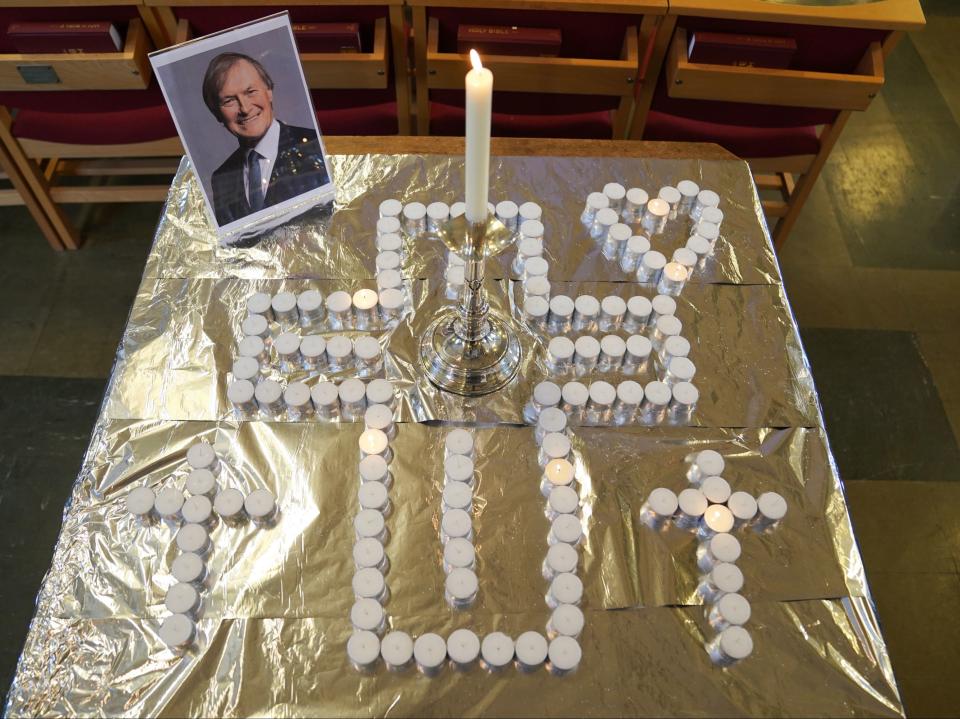 Candles and a photo of Sir David Amess at the church service (PA)