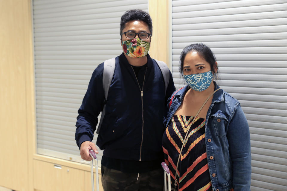 Travelers Hikari Miyashita, left, and Kathleen Miyashita are seen inside the Daniel K. Inouye International Airport Thursday, Oct. 15, 2020, in Honolulu. The Miyashitas decided against taking a pre-travel COVID-19 test before arriving in Hawaii and chose to do a mandatory 14-day quarantine at a relative's property on Oahu. (AP Photo/Marco Garcia)