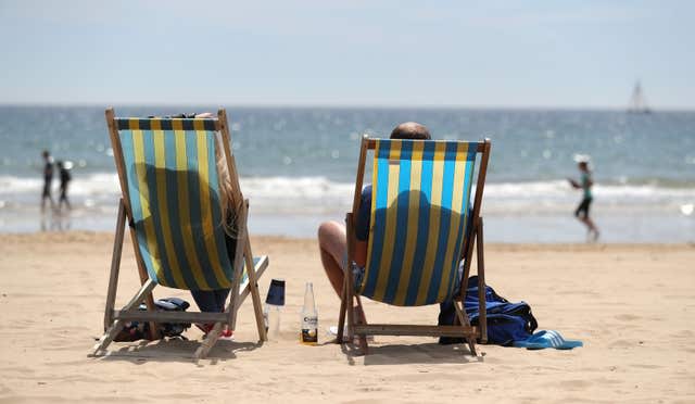 People in deckchairs on a beach