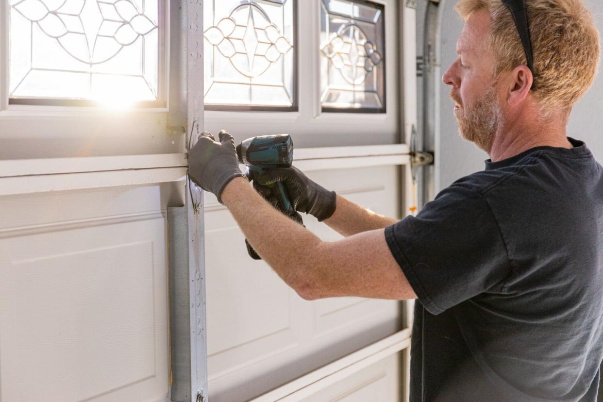 man replacing garage door