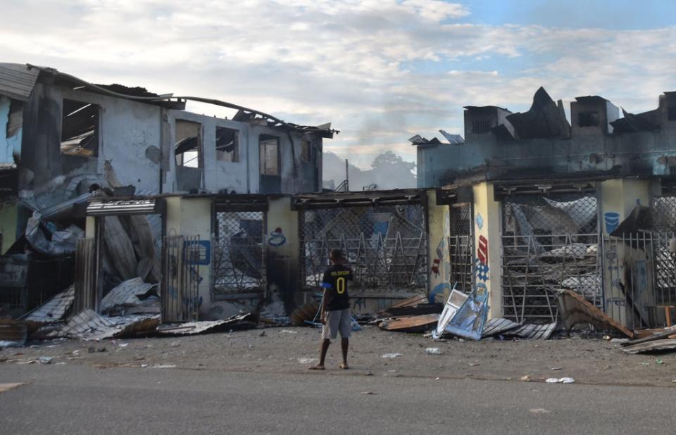 File photo: A man looks at damage caused by riots in Honiara, the Solomon Islands, 27 November 2021 (AFP via Getty Images)