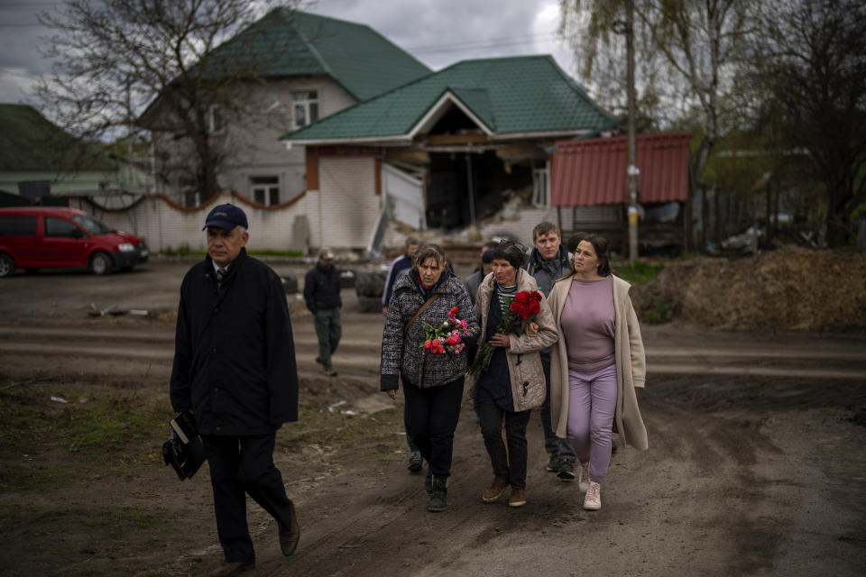 Tetiana Boikiv, 52, center, walks with friends and neighbors during a funeral service for her husband, Mykola "Kolia" Moroz, 47, in the Ukrainian village of Ozera, near Bucha, on Tuesday, April 26, 2022. Russian soldiers took Kolia from his house on March 15. He was tortured and shot, his body found two weeks later in a village 15 kilometers (9 miles) away where Russians set up a major forward operating base for their assault on the capitol, Kyiv. (AP Photo/Emilio Morenatti)