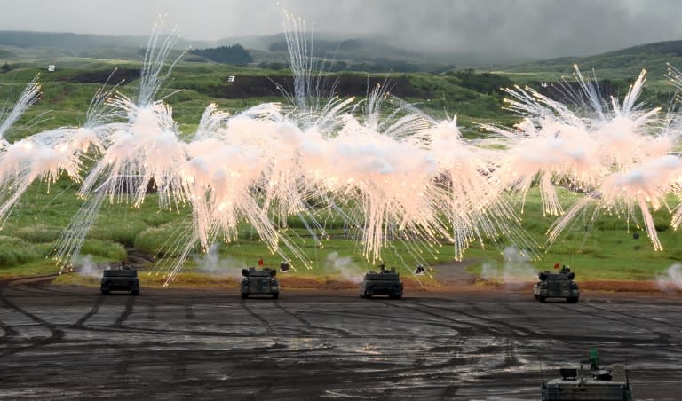 Japanese Ground Self-Defense Force tanks move amongst an umbrella of barrage during an annual live fire exercise, at the Higashi-Fuji firing range in Gotemba, Shizuoka prefecture, on August 25, 2016