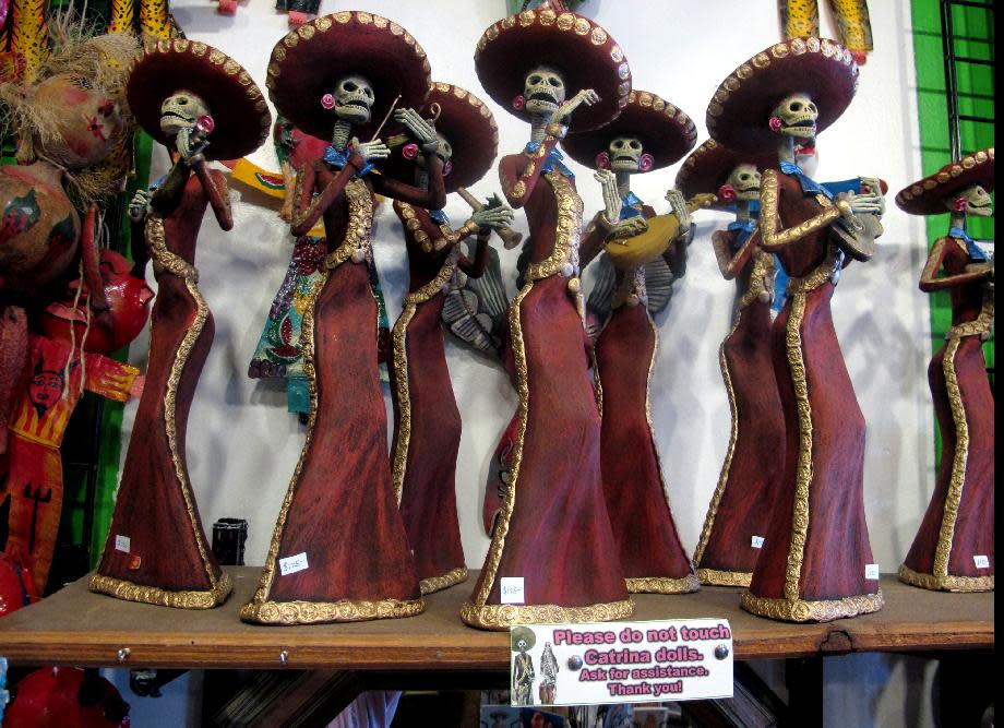 In this May 8, 2013 photo, artwork is shown at Masks y Mas, an Albuquerque shop that sells 'Day of the Dead' art year round. Disney announced Tuesday that it was a withdrawing a "Dia de los Muertos" trademark request it made to the U.S. Patent and Trademark Office amid uproar on social media from Latino activists, writer and artists. Disney had sought to secure naming right for an upcoming animated movie inspired by the holiday. Critics said the move to trademark a cultural holiday was insensitive. (AP Photo/Russell Contreras)