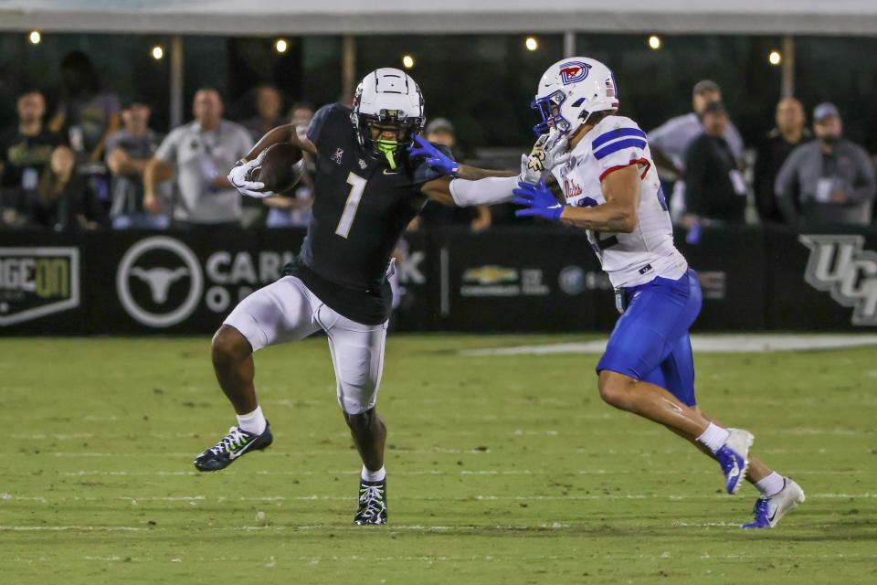 Oct 5, 2022; Orlando, Florida, USA; UCF Knights wide receiver Javon Baker (1) runs the ball against Southern Methodist Mustangs safety Nick Roberts (22) during the second half at FBC Mortgage Stadium. Mandatory Credit: Mike Watters-USA TODAY Sports