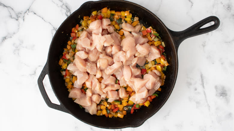 chicken in skillet with veggies