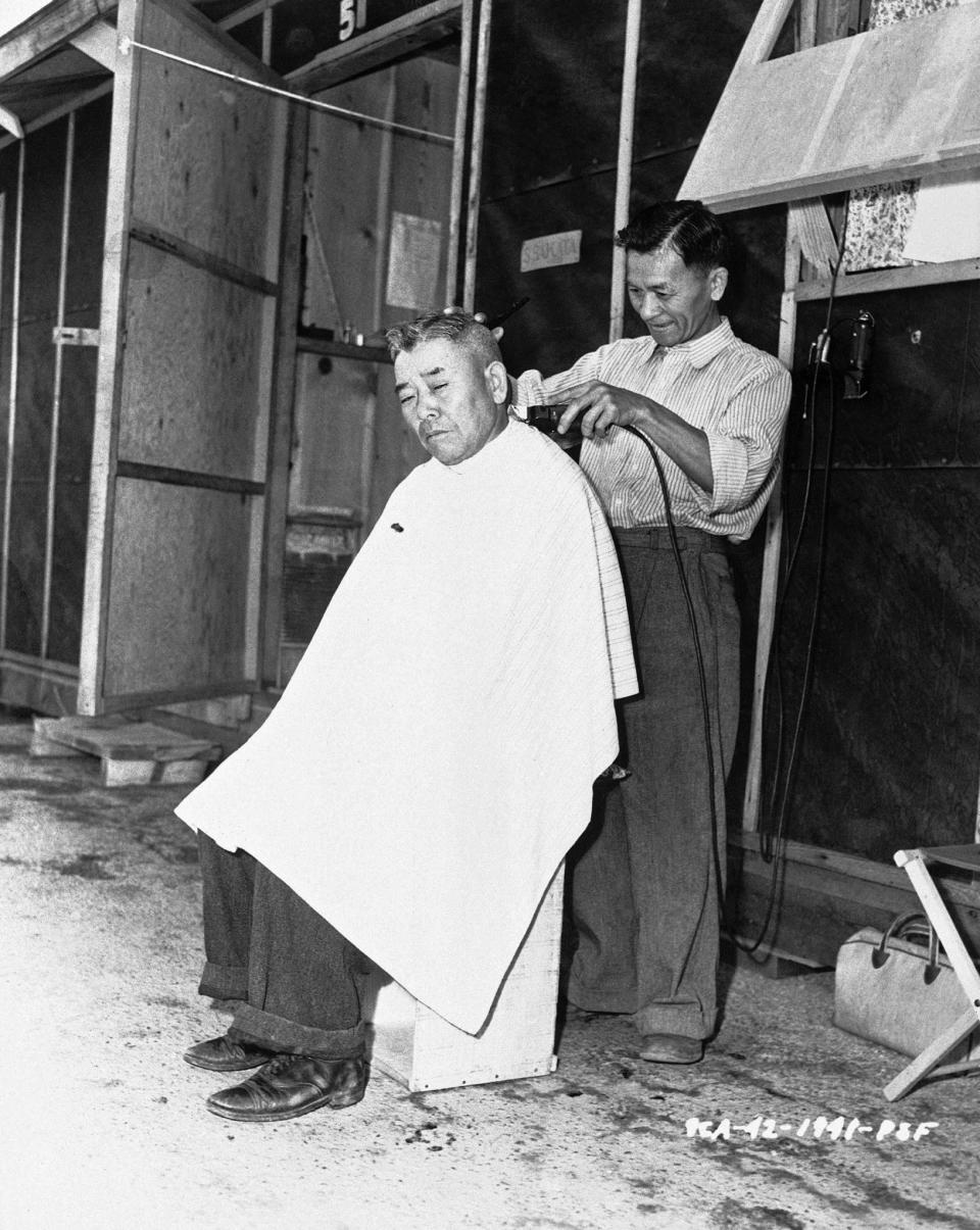 <p>The barbers at the center set up in the street in Santa Anita, California July 2, 1942. Internees lucky enough to fill necessary jobs are paid the following scale: $16 a month for the professional class, $12 for skilled labor, $8 for common labor. (AP Photo) </p>