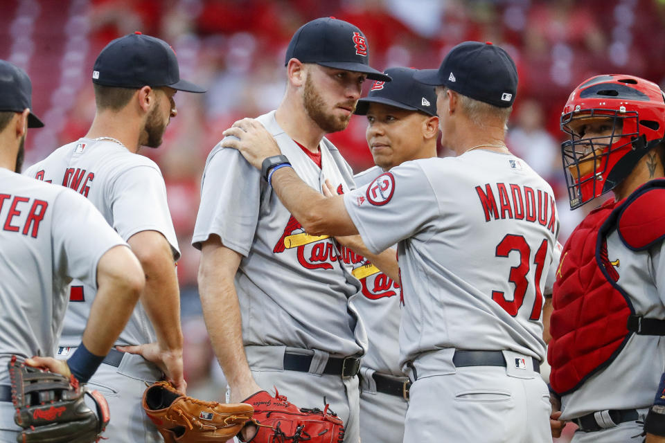 St. Louis Cardinals starting pitcher Austin Gomber, center, meets with pitching coach Mike Maddux (31) during the third inning of the team's baseball game against the Cincinnati Reds, Tuesday, July 24, 2018, in Cincinnati. (AP Photo/John Minchillo)
