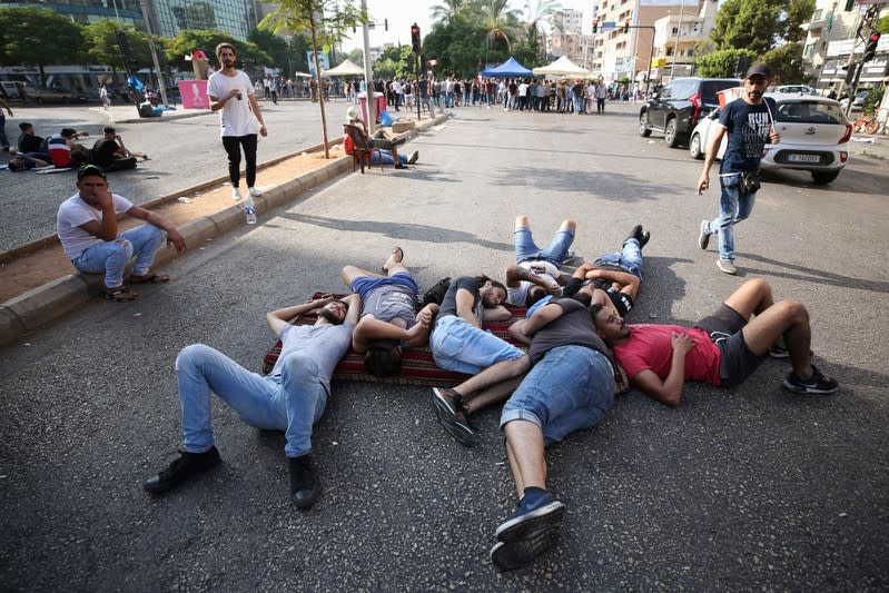 Demonstrators sleep on the ground as they block a street during a protest targeting the government over an economic crisis in the port city of Sidon