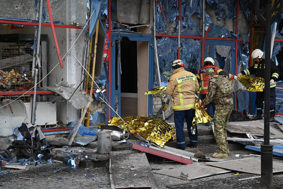 In this photo released by Belgorod region governor Vyacheslav Gladkov's telegram channel on Thursday, Feb. 15, 2024, firefighters stand at a damaged building in Belgorod, Russia. Officials say a missile strike on the Russian city of Belgorod near the Ukraine border has killed five people, including a child, and injured 18 others, in what appears to be the latest exchange of long-range missile and rocket fire between the two countries. (Belgorod region governor Vyacheslav Gladkov telegram channel via AP)