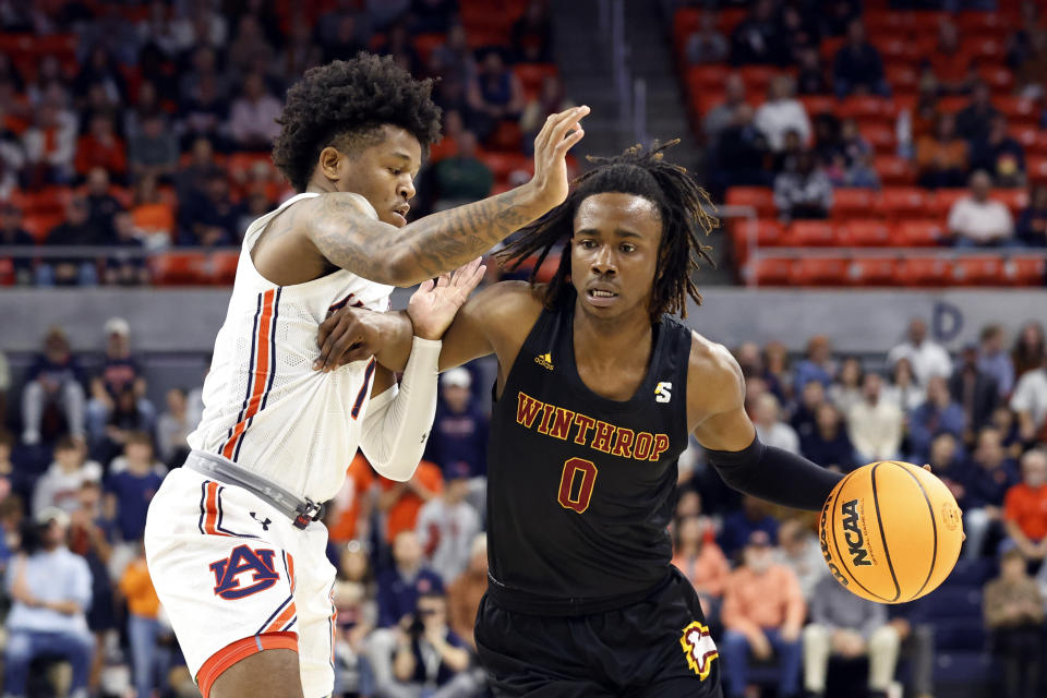 Winthrop guard Sin'Cere McMahon (0) dribbles around Auburn guard Wendell Green Jr. (1) during the first half of an NCAA college basketball game Tuesday, Nov. 15, 2022, in Auburn, Ala. (AP Photo/Butch Dill)