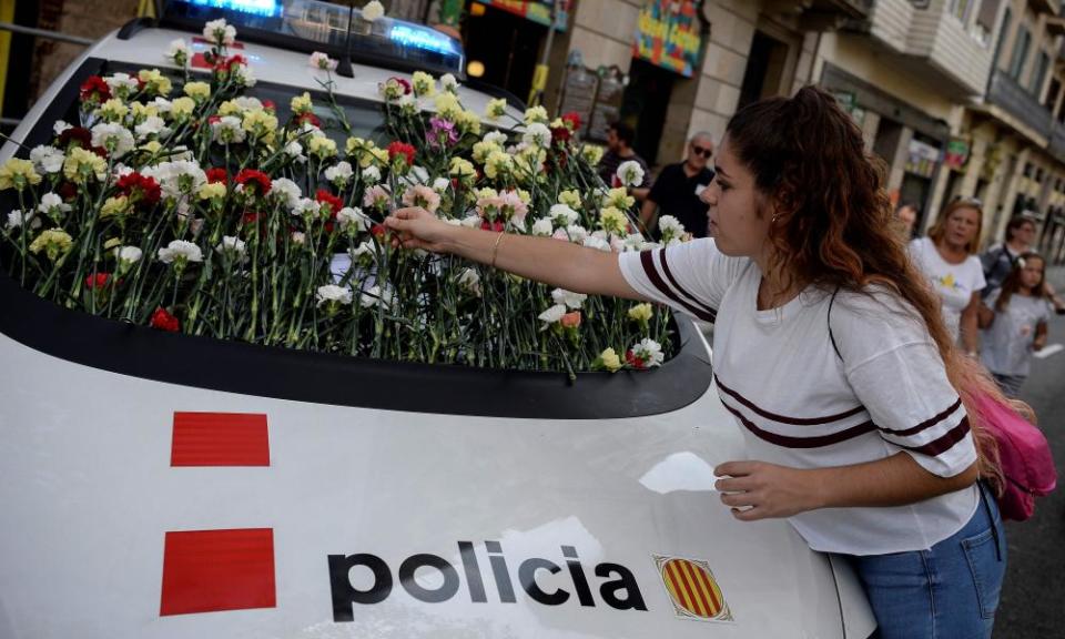 A woman puts a flower on a Catalan police car during a pro-independence referendum rally in Barcelona