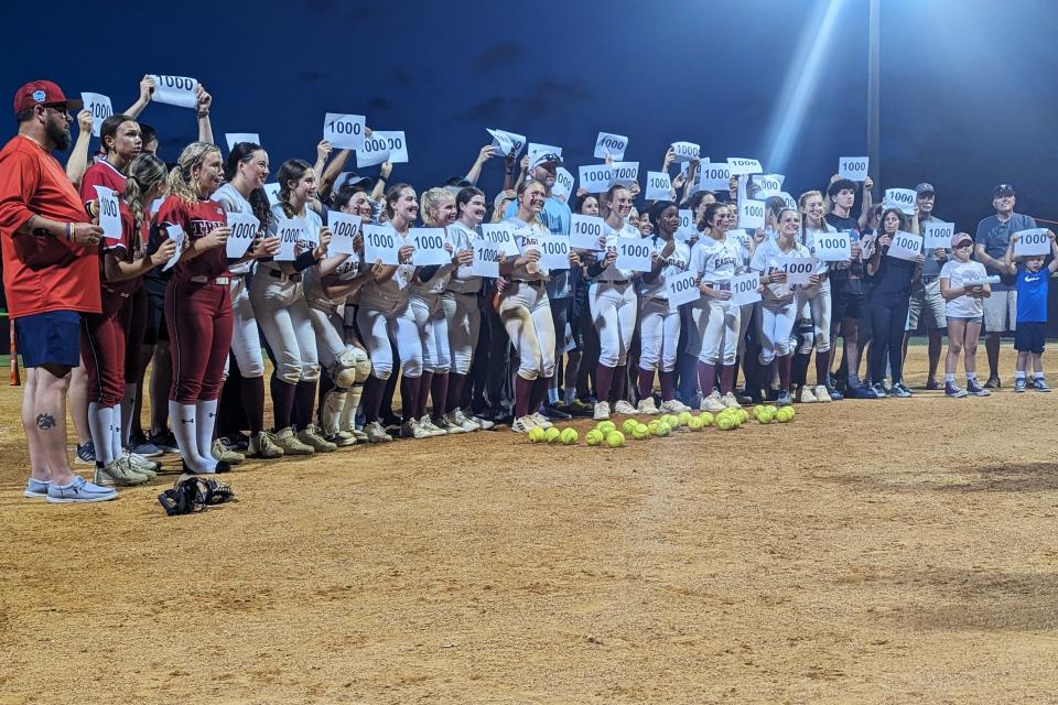 Players, coaches and fans hold "1,000" signs recognizing the 1,000 career strikeouts for Episcopal senior pitcher Grace Jones (center) following Thursday's FHSAA District 4-3A high school softball final against Baldwin.