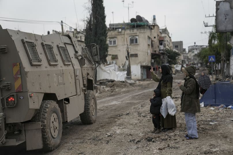 A Palestinian woman flashes a V-sign towards Israeli troops during an army raid in the Tulkarem refugee camp, West Bank, Wednesday, Jan.17, 2024.