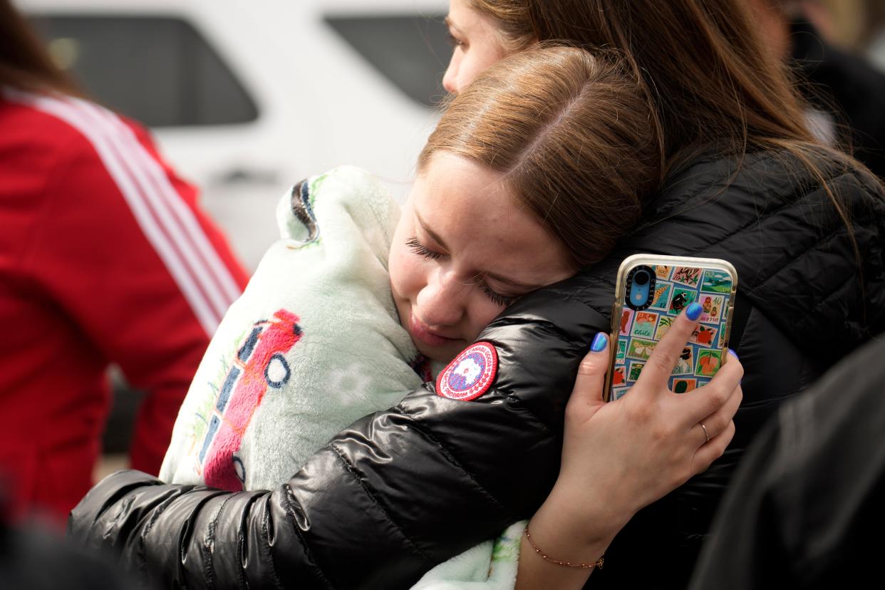 Two women hug when reunited following a shooting at East High School, Wednesday, March 22, 2023, in Denver (AP)