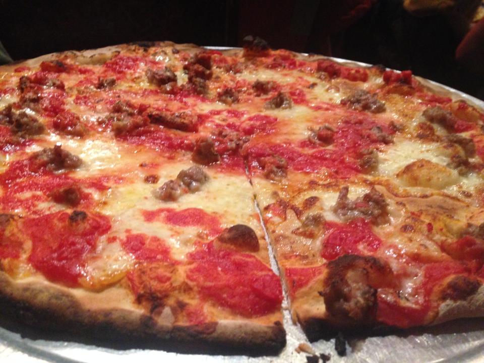 A fired brick oven tomato pizza pie.