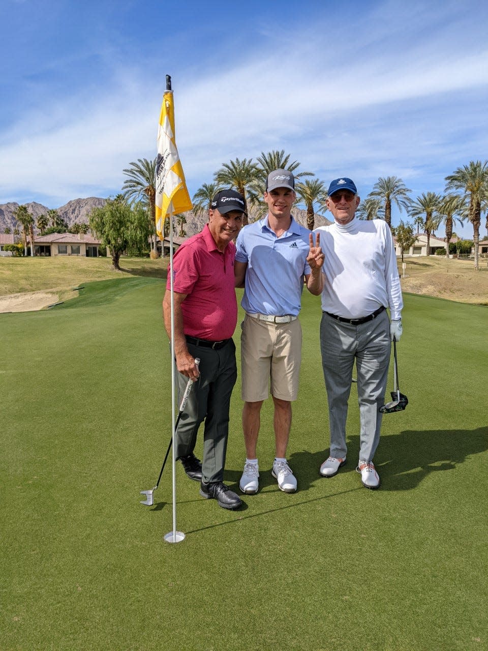 Danny Syring, center, celebrates his second double eagle of his round last Sunday with his father Kevin, left, and Jay Green of La Quinta, right.