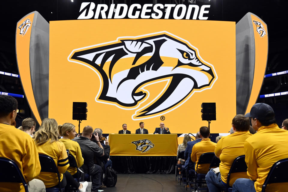 Former Nashville Predator head coach Barry Trotz, right, speaks as general manger David Poile, center, who is retiring in June, listens along with President and CEO Sean Henry, during a news conference Monday, Feb. 27, 2023, in Nashville, Tenn. Trotz will become the next general manager of the Nashville Predators in July. (AP Photo/Mark Zaleski)