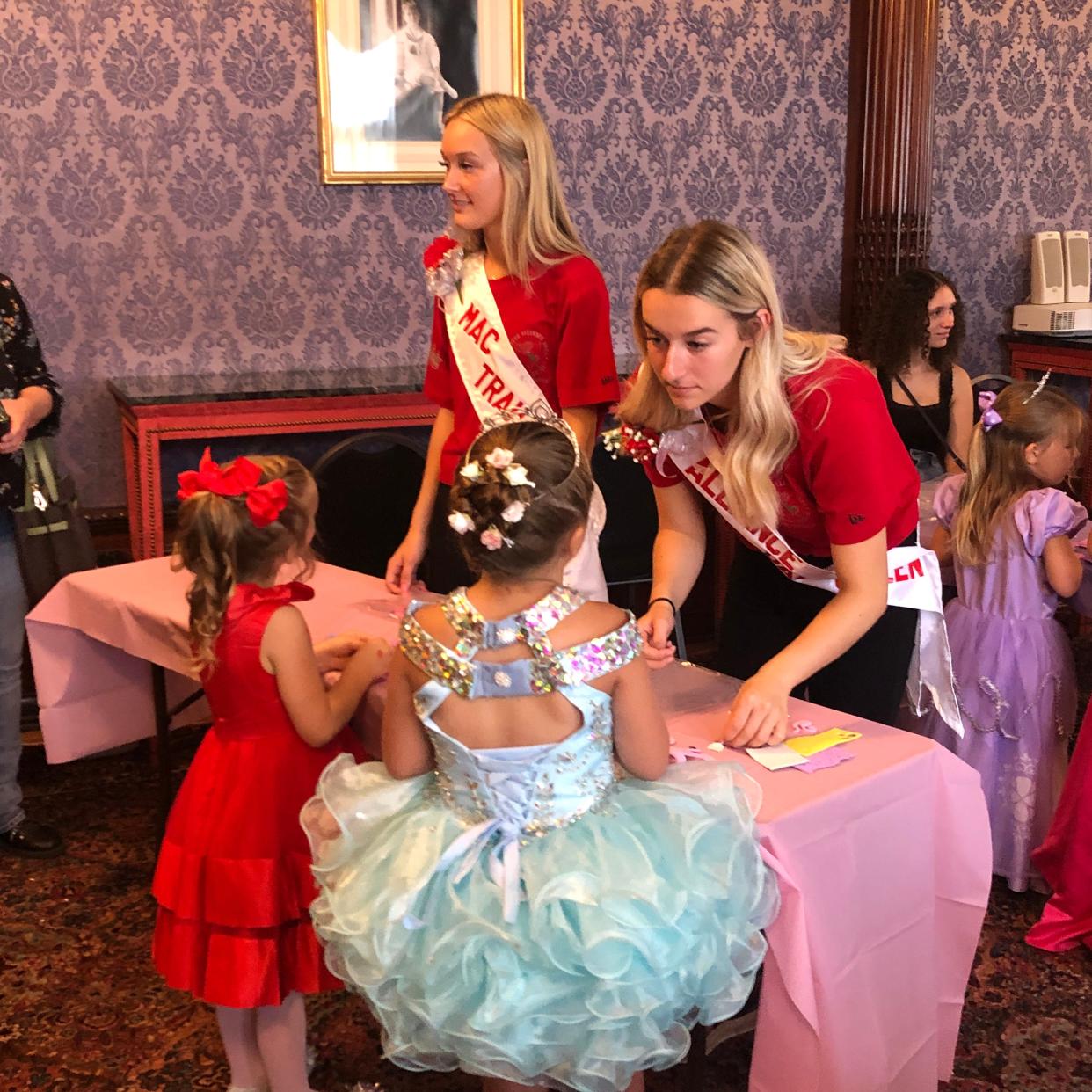 Kenna McElroy, left, and Olivia Bertolini, right, who are participating in the 2022 Carnation Festival Queen Pageant on July 30, 2022, helped little girls make crowns at "A Royal Afternoon at The Castle" Sunday, June 24, 2022, at Glamorgan Castle in Alliance.