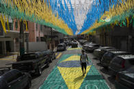 A man walks along a street decorated for the upcoming World Cup in Rio de Janeiro, Brazil, Wednesday, May 14, 2014. The international soccer tournament will be the first in the South American nation since 1950. (AP Photo/Felipe Dana)