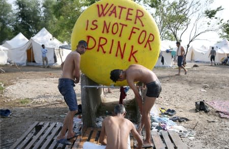 FILE PHOTO: Migrants take a shower in camp Vucjak in Bihac