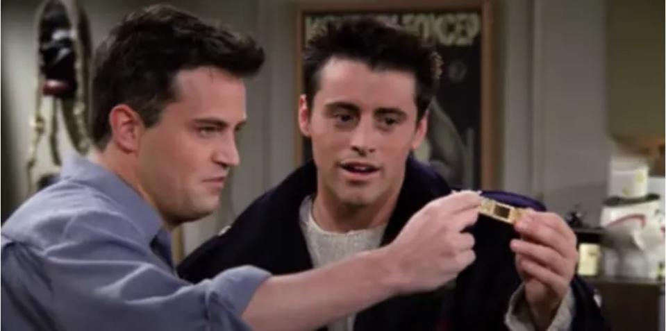 Joey and Chandler holding and looking at a bracelet