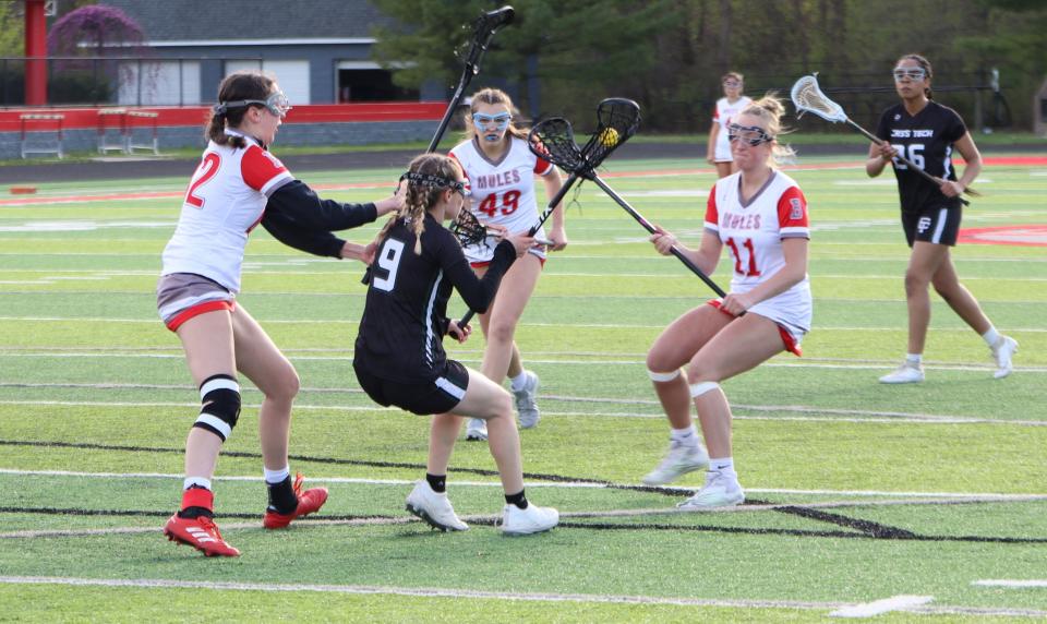 Kadie Morse, Kamryn Puccetti, and Raegan VanEeckhoutte of Bedford surround a Cass Tech player on Friday, April 19, 2024.