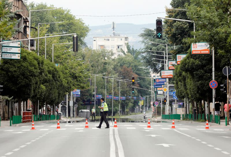 Police officers patrol on empty streets as supporters of North Macedonia's biggest opposition party VMRO-DPMNE rally in Skopje