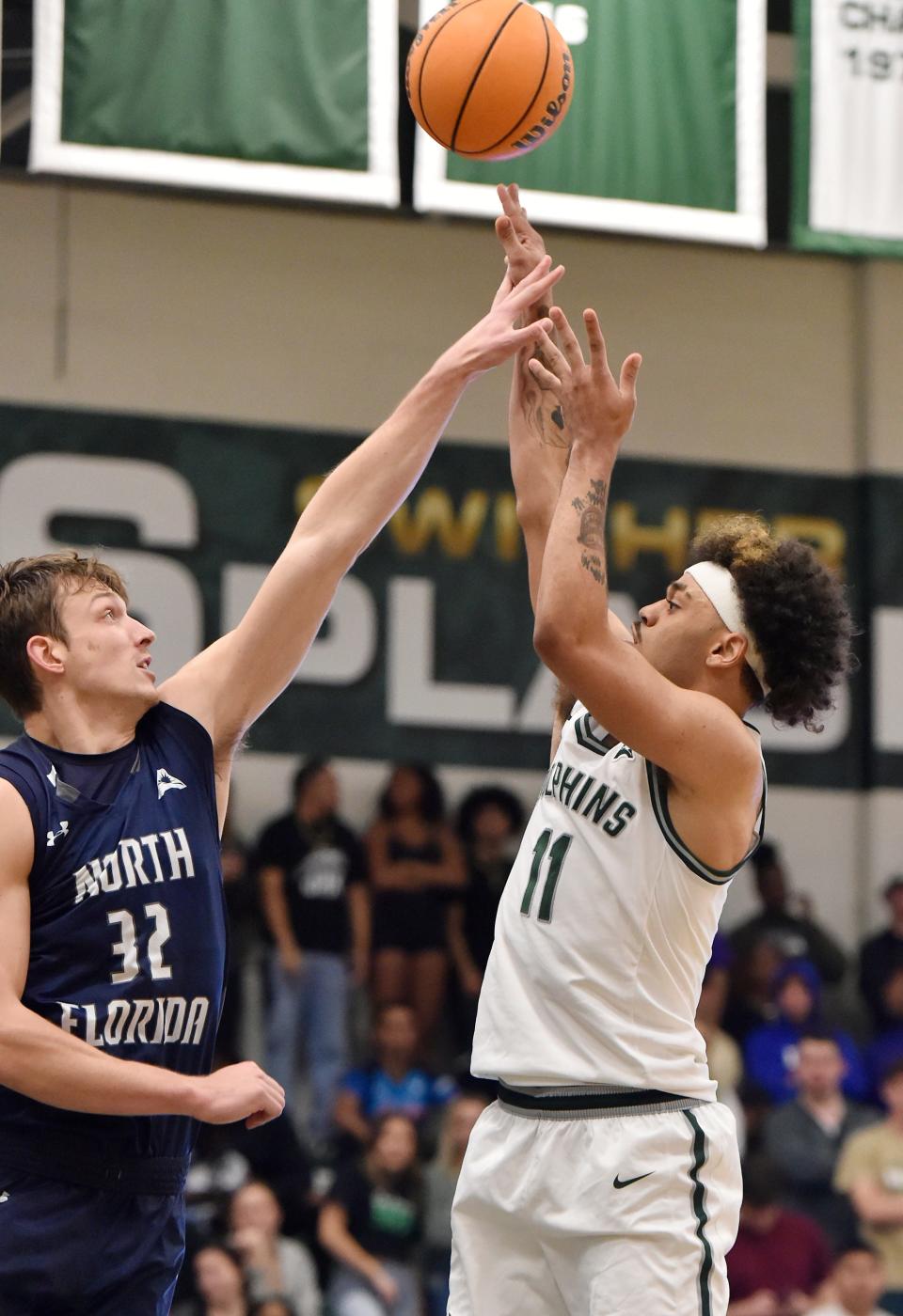 Jacksonville guard Marcus Niblack (11) tries to get a shot past North Florida forward Jake van der Heijden (32) during a February ASUN basketball game.