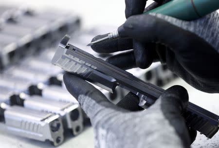 An employee works on a part of a Heckler & Koch P 8 handgun during a guided media tour at their headquarters in Oberndorf, 80 kilometers southwest of Stuttgart, Germany, May 8, 2015. REUTERS/Ralph Orlowski