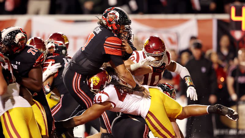 Utah Utes quarterback Cameron Rising (7) is hit and falls over USC Trojans linebacker Tuasivi Nomura (44) for a touchdown at Rice Eccles Stadium in Salt Lake City on Saturday, Oct. 15, 2022. Utah won 43-42.