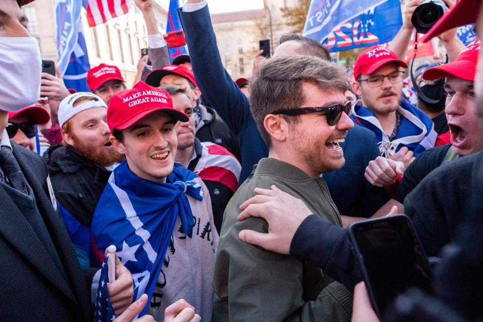 Nick Fuentes right-wing podcaster, center right in sunglasses, greets supporters before speaking at a pro-Trump march, Nov. 14, 2020, in Washington, D.C.