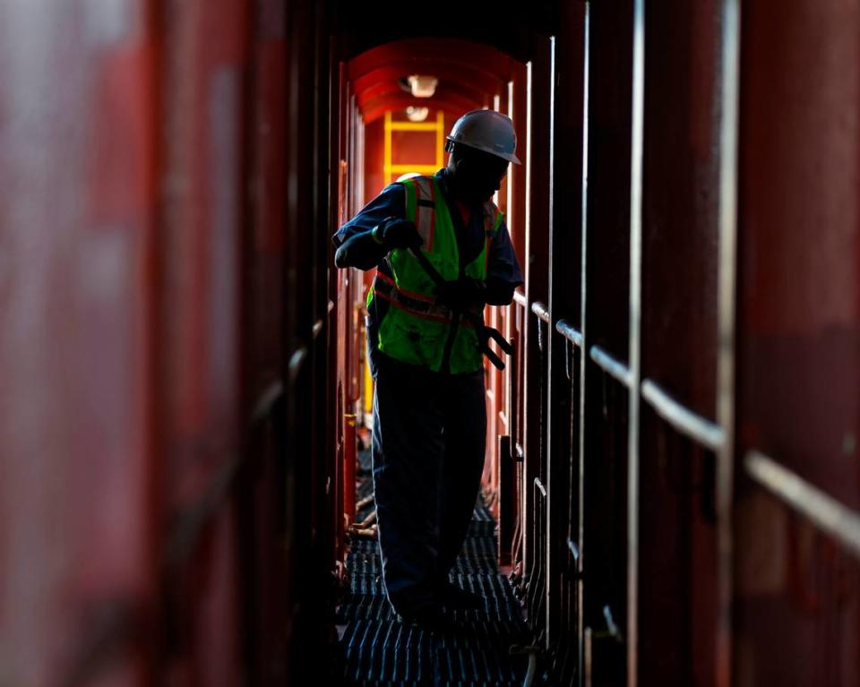 Longshoreman Michael Daniels works to unhook containers inside a docked cargo ship at PortMiami on Saturday, February 20, 2021. Daniels, a lasher, has been working as a longshoreman for 40 years.