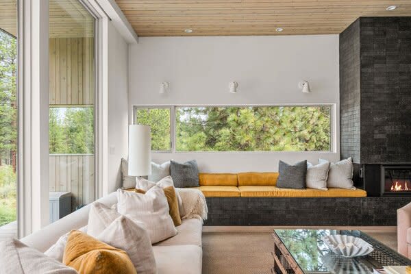 Crisp white walls complement the striking blend of wood, glass, and brick in the living room.