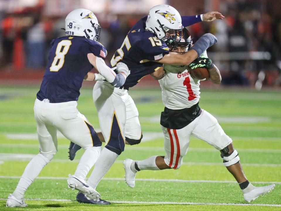 Tallmadge's Mark Manzo and Noah Robinson team up to stop Green's Antonio Martin in the second half of their game at Tallmadge High School Stadium on Friday.