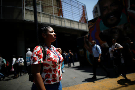 A woman stands in front of a closed metro station during a blackout in Caracas, Venezuela March 25, 2019. REUTERS/Carlos Garcia Rawlins