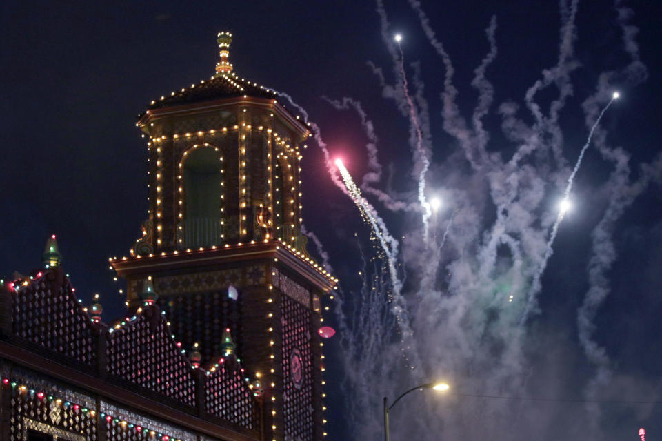 Plaza lights come on as fireworks light up the sky during the Plaza Lighting Ceremony in Kansas City, Mo., Thursday, Nov. 28, 2019. The Country Club Plaza is a famous shopping district in Kansas City. This is the 90th year of the Plaza Lights. (AP Photo/Orlin Wagner)