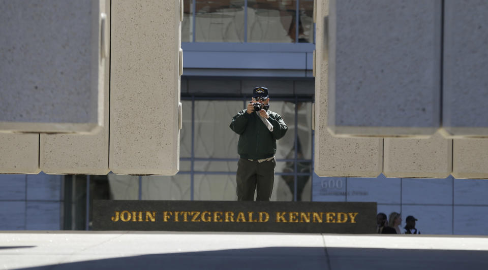 A visitor photographs the John Fitzgerald Kennedy Memorial in downtown Dallas, Tuesday, Nov. 12, 2013. Church bells tolling throughout Dallas and a moment of silence at 12:30 p.m. on Nov. 22 will mark the moment 50 years ago when President John F. Kennedy was assassinated. A year of commemorative events organized by organizations throughout the city culminates this month with a solemn ceremony the city of Dallas has planned in Dealey Plaza, where Kennedy’s motorcade was passing as shots rang out. (AP Photo/LM Otero)