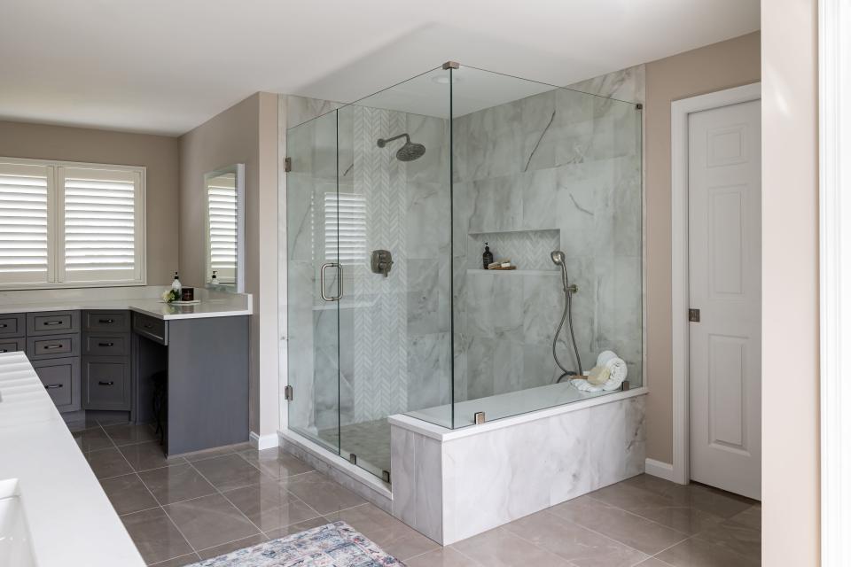 The shower features built-in shelving at this remodeled home in Plainview.