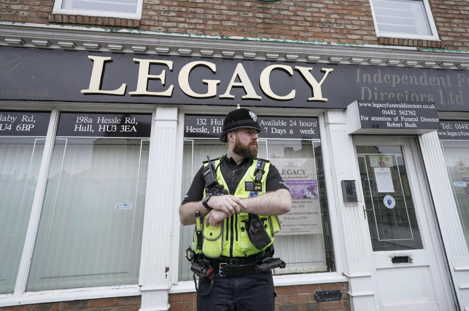 Police stand guard outside the Beckside branch of Legacy Independent Funeral Directors, in Hull, England, Saturday, March 9, 2024. Police in northern England say they have removed 34 bodies from a funeral home and arrested a man and woman on suspicion of fraud and preventing lawful burials. The arrests Sunday follow several days of investigation at Legacy Funeral Directors in Hull and two related funeral homes. (Danny Lawson/PA via AP)