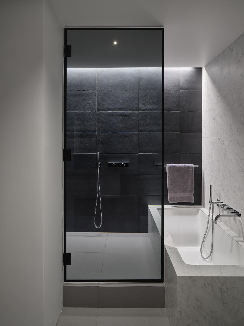 A modern monochrome bathroom with a large bath and a walk-in shower