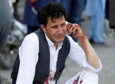 An Afghan man talks on his phone after a suicide attack in Kabul, Afghanistan July 23, 2016. REUTERS/Omar Sobhani