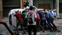 Un grupo de gente volteando un auto de la policía